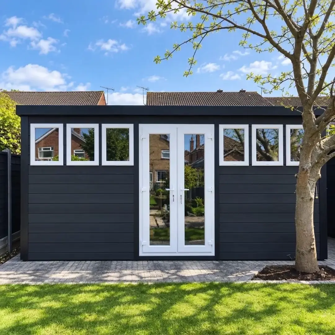 Black Cotswold workshop with white double doors and a row of windows